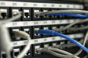 Baies de réseau et câbles illustrant les infrastructures numériques et la connectivité